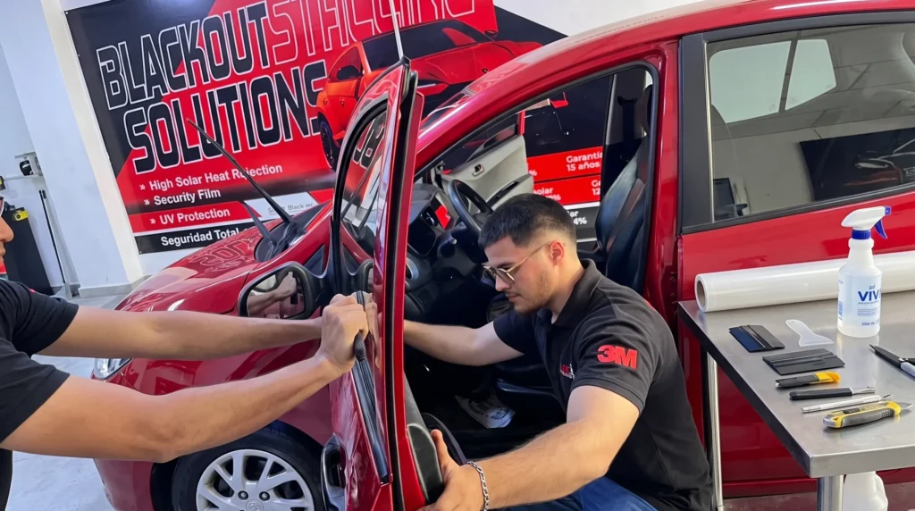 Imagen de portada para la sección de láminas de seguridad automotriz en MJE Polarizados La Victoria. Se muestra a un técnico aplicando una lámina de 12 micras anti-bujiazo.